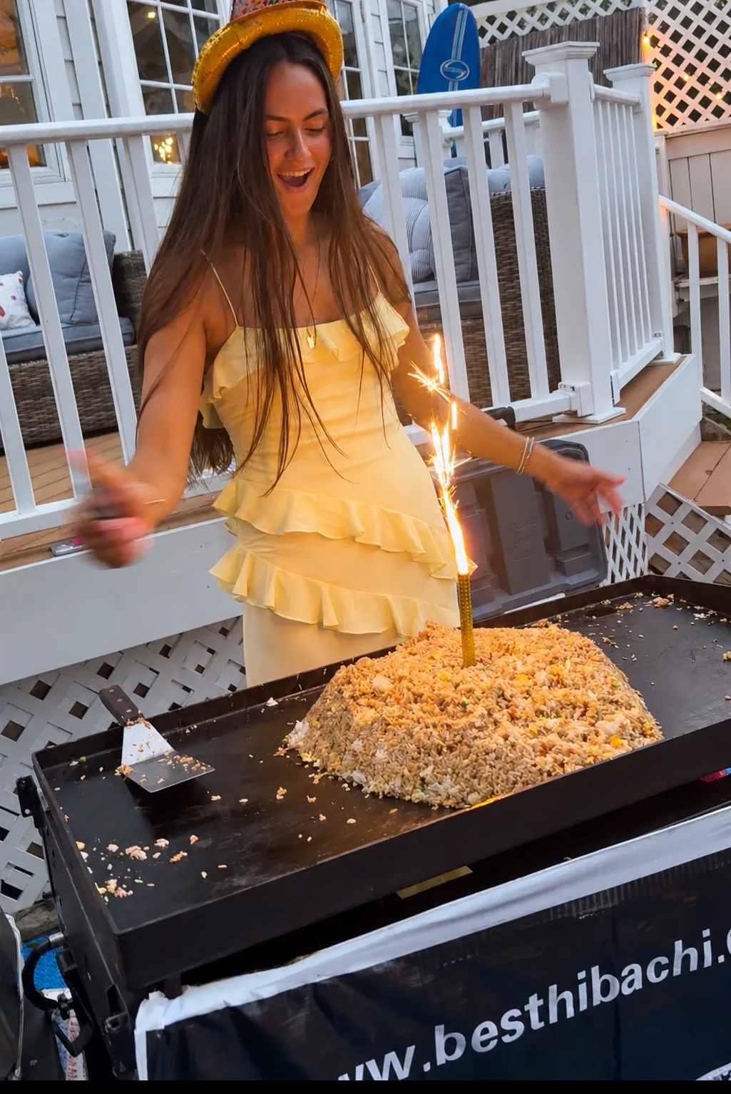 Birthday guest celebrating beside a hibachi grill at a backyard party